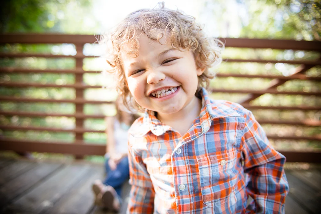 A child laughing on a wooden bench